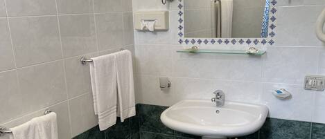 Une salle de bain équipée d’un lavabo, d’un bidet et d’un porte-serviettes.