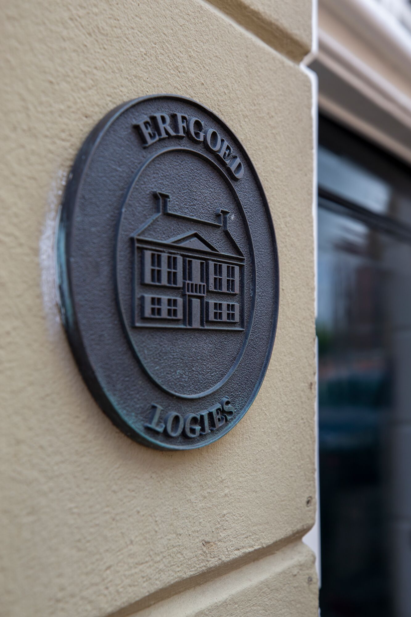 A metal plaque with the inscription "ERFGOED LOGIES" and a building illustration.
