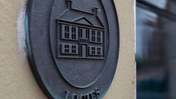 A metal plaque with the inscription "ERFGOED LOGIES" and a building illustration.