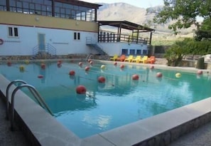 Alberca al aire libre y camastros 