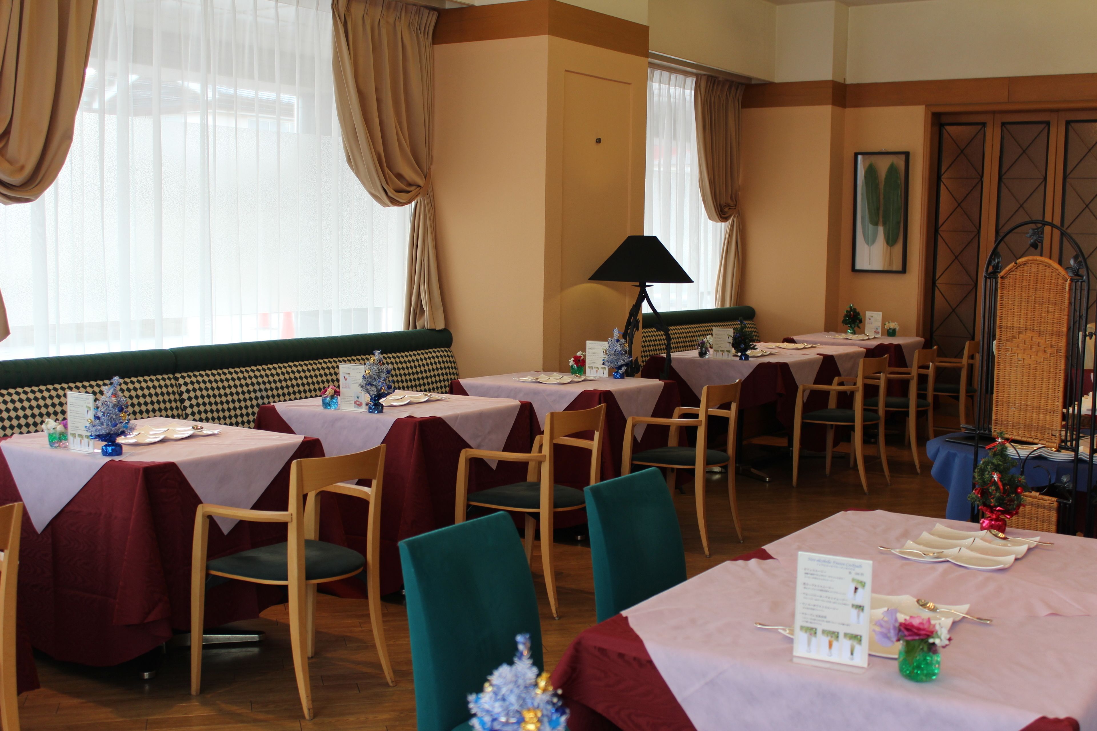 Un comedor con varias mesas dispuestas para el servicio, cada una con un atril para el menú.