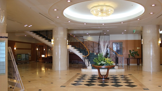 A spacious lobby with a grand staircase, a chandelier, and a checkered floor. - Grand Hotel Hakusan (Hakusan)
