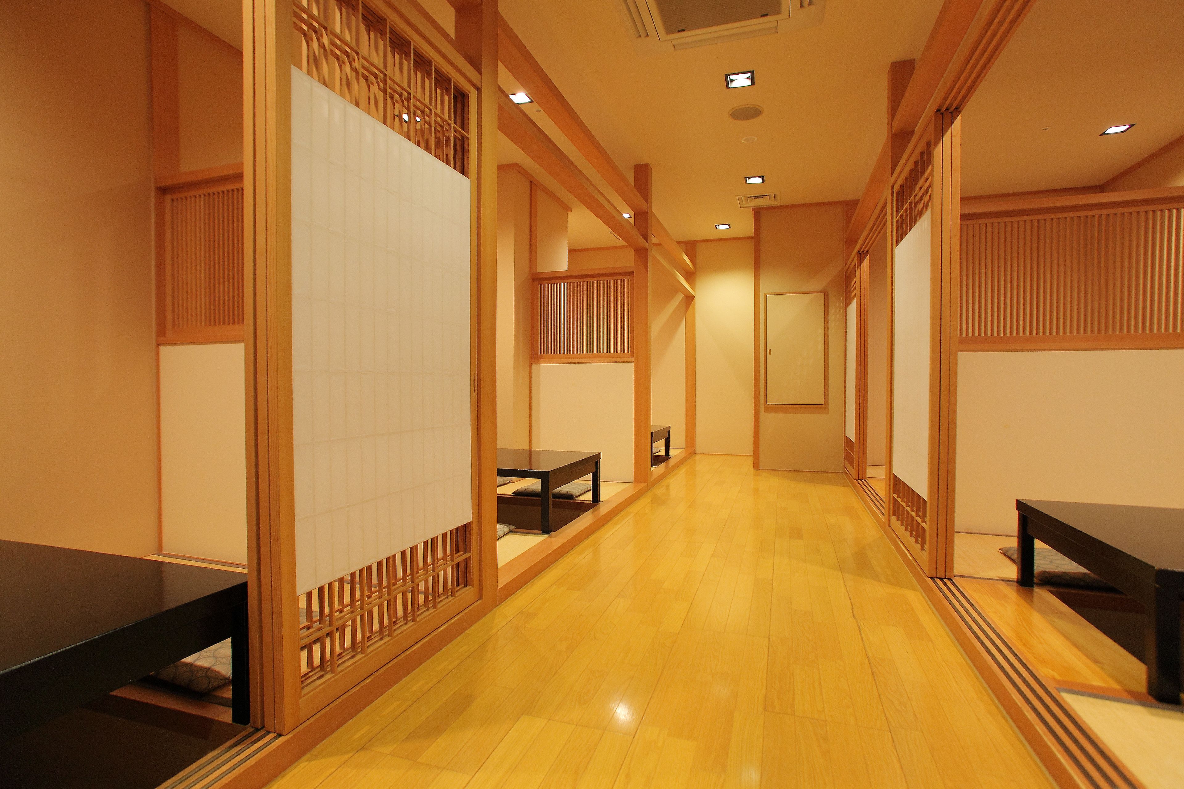Un couloir doté d’un plancher en bois et de portes coulissantes traditionnelles.