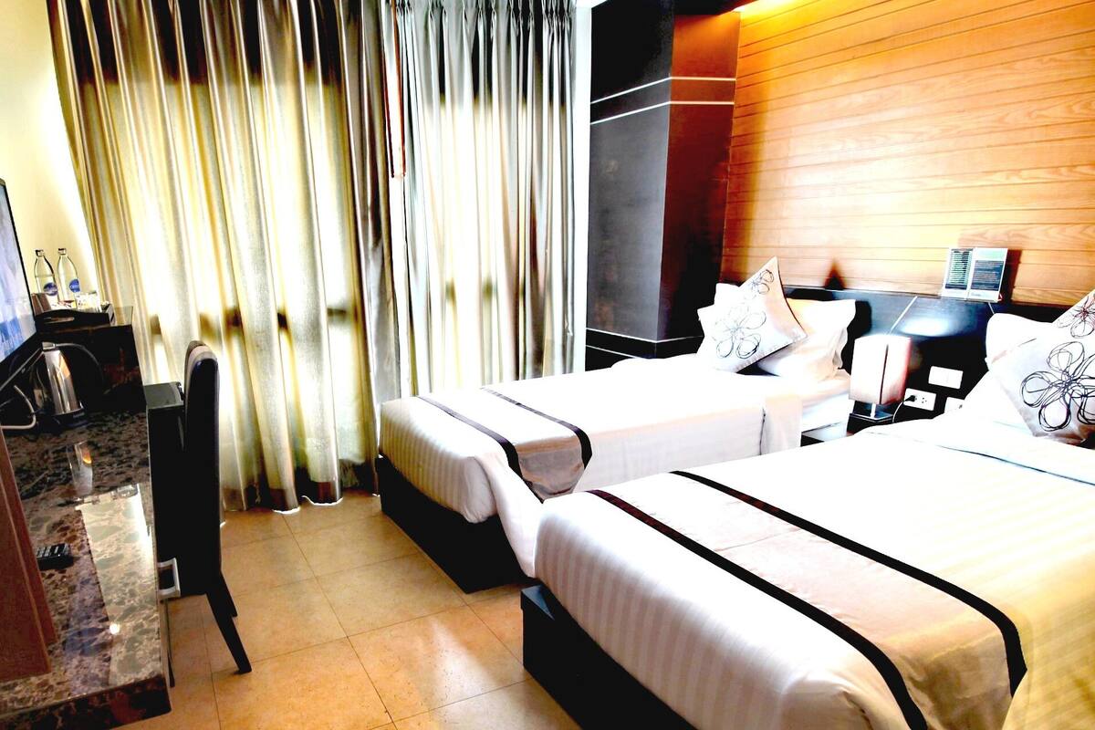 Una habitación de hotel con cama, escritorio, silla y televisor.