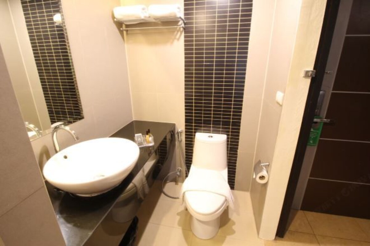 A bathroom with a white sink, a toilet, and a towel rack.