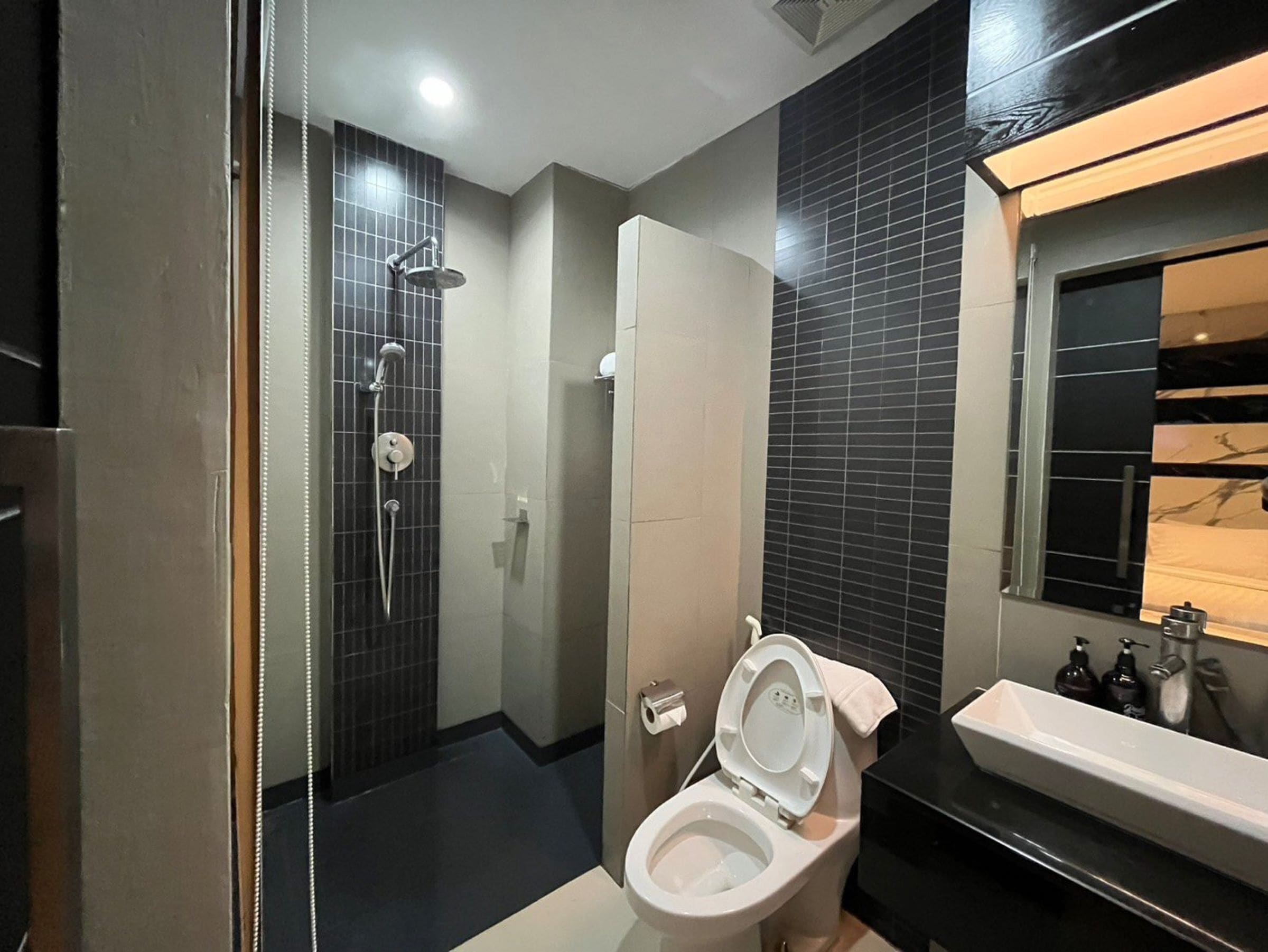 A modern bathroom with a shower, toilet, and sink.