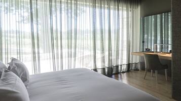 Een moderne slaapkamer met een groot bed, een bureau en een stoel.