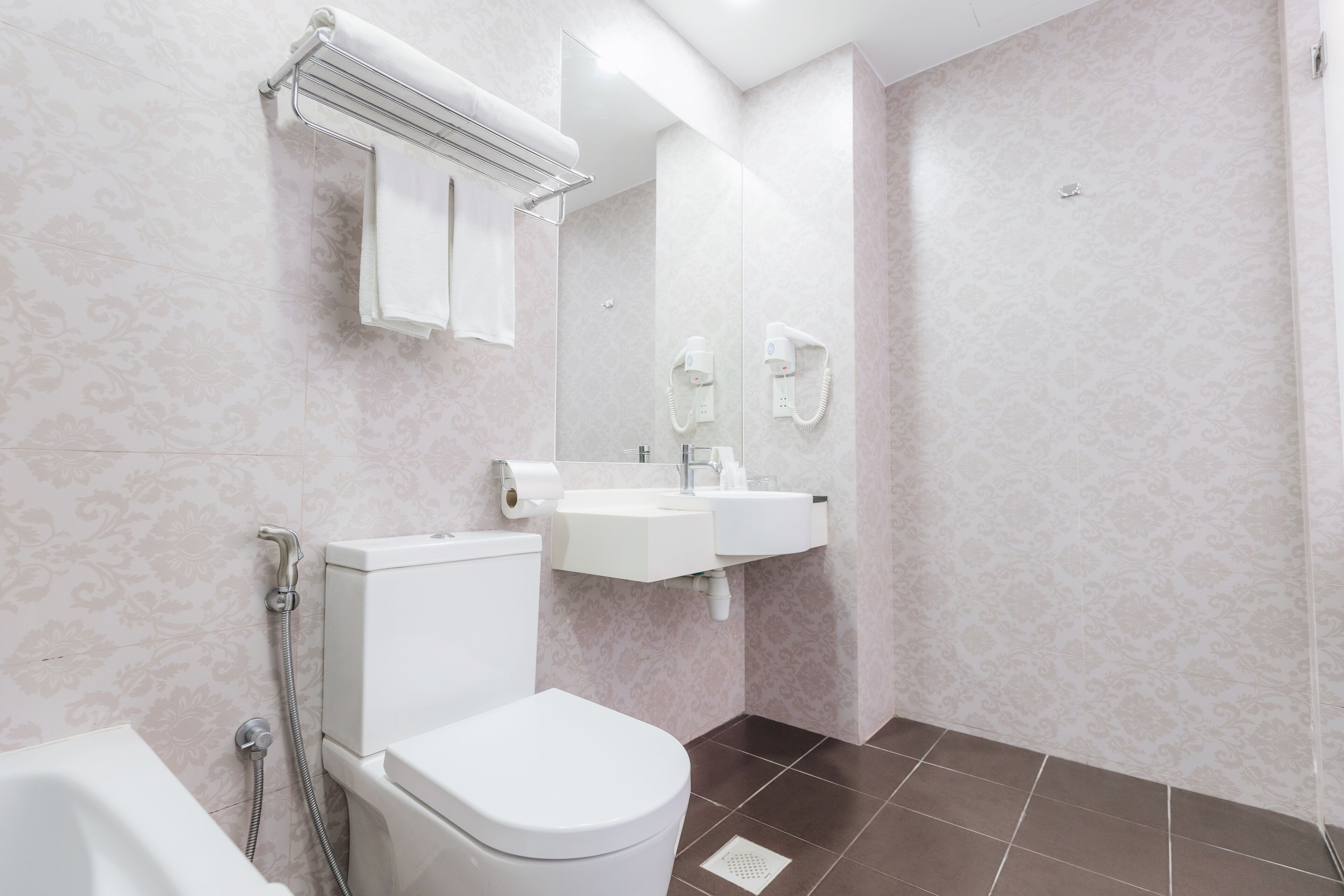 Un baño moderno con inodoro, lavamanos y ducha.