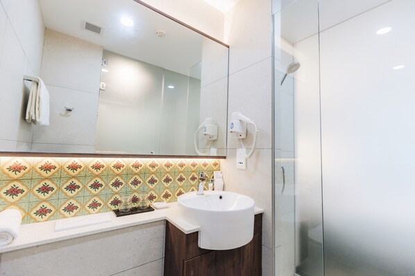 A modern bathroom with a large mirror, a sink, and a shower. - Santa Grand Hotel East Coast, a NuVe Group Collection (Singapore)
