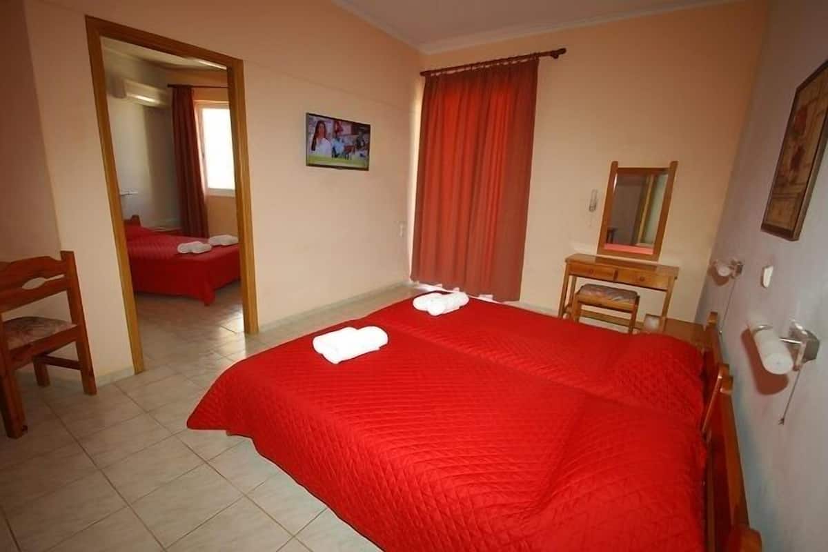 Une chambre à coucher avec un grand lit, une chaise en bois, une petite table et un miroir.