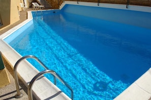 Utomhuspool, parasoller och solstolar