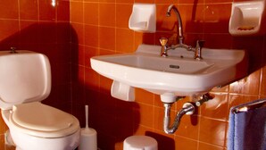 Un bagno con il water, un lavandino e uno specchio.