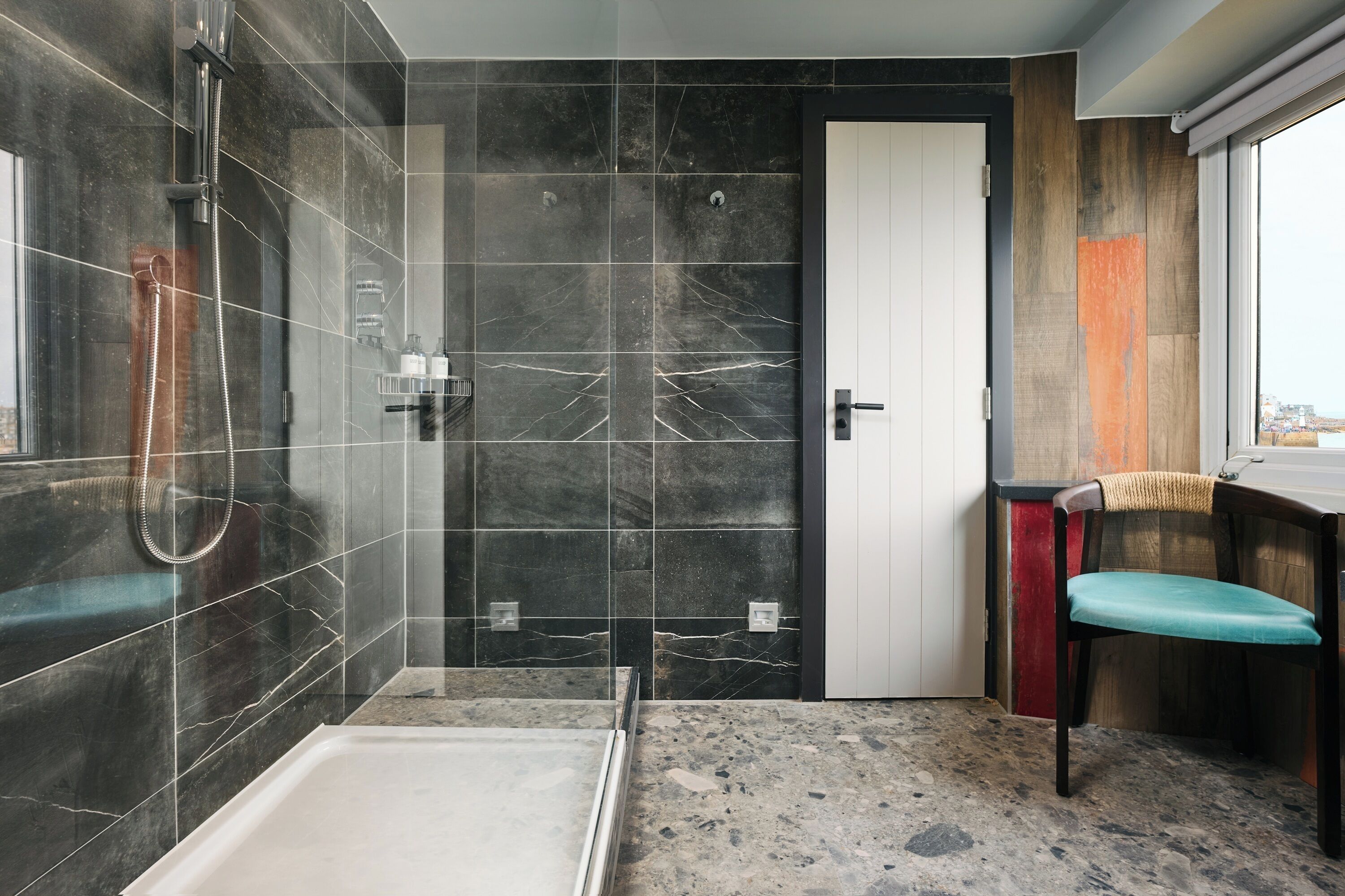A modern bathroom with a shower, a toilet, and a sink.