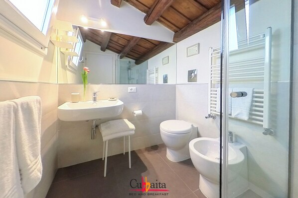 A bathroom with a sink, toilet, bidet, and a glass shower enclosure. - B&B Cubbaita (Palermo)