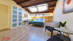 A cozy bedroom with a bed, a desk, and a chair. There is a skylight above the bed and a window on the left. - B&B Cubbaita (Palermo)