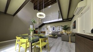A modern living room with a glass dining table, yellow chairs, a grey sofa, and a staircase leading to an upper level. - B&B Cubbaita (Palermo)