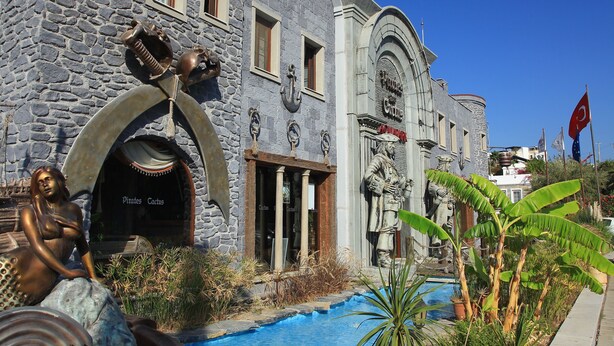 A stone building with a pool, statues, and a flag. - Mirage Family Club - All Inclusive (Bodrum)