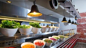 A buffet setup with various food items and a modern kitchen in the background. - Mirage Family Club - All Inclusive (Bodrum)