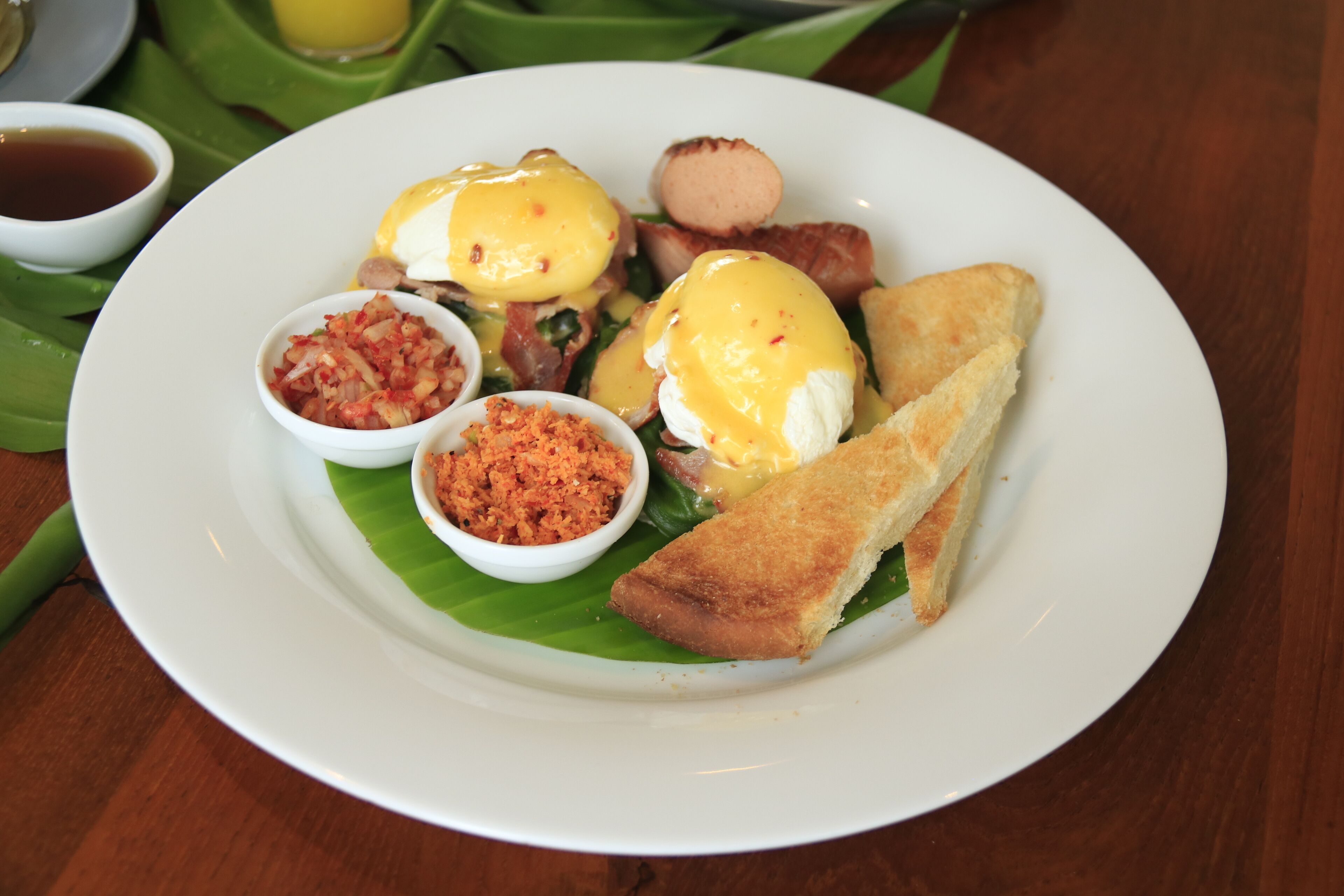 A plate of food with toast, eggs, and condiments.