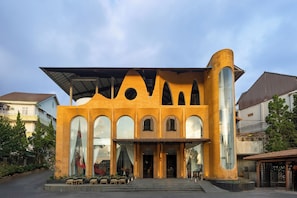 A building with a unique architectural design featuring arched windows and a curved structure. - Zen Valley Dalat (Xuan Huong - Da Lat)