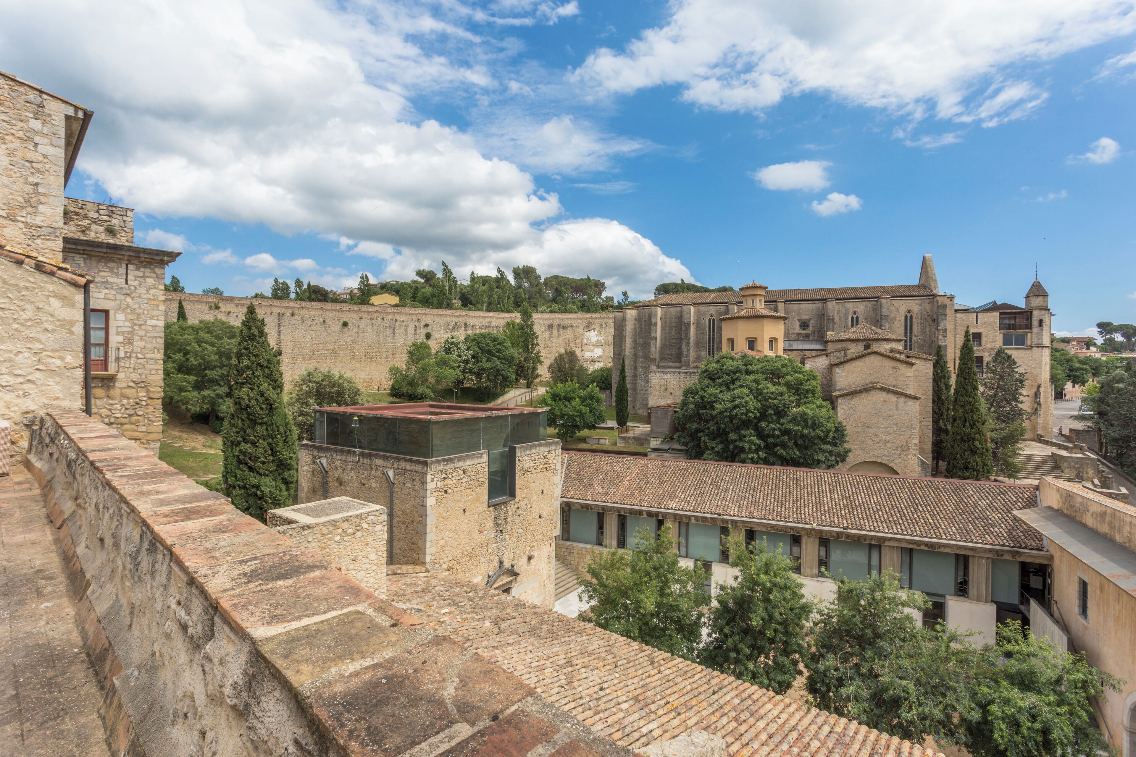 A historic stone building with a courtyard, featuring a mix of architectural styles including a prominent tower and a church-like structure.