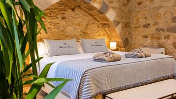 Un lit avec une couvre-lit à rayures, deux oreillers et une lampe de chevet.