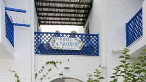 A courtyard with a blue door, white walls, and a sign for Hotel O Margaritissa. - Maganas Hotel (Astypalaia)