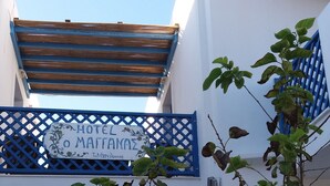 A hotel entrance with a blue gate, a staircase, and a sign reading "HOTEL O MAITANAZ". - Maganas Hotel (Astypalaia)