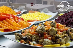 Una mesa con varios platos, incluyendo maíz, zanahorias y una ensalada de verduras mixtas.