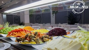 A buffet with various dishes including vegetables, meats, and cheese.