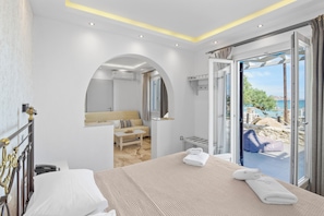 Een hotelkamer met een bed, een badkamer en een balkon met uitzicht.