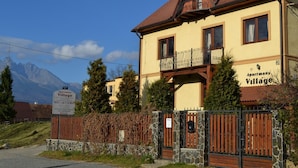 A two-story building with a balcony, labeled "Aptman Village." - Apartmány Village (Velky Slavkov)