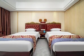 A hotel room with two beds, a wooden headboard, and a nightstand with lamps.