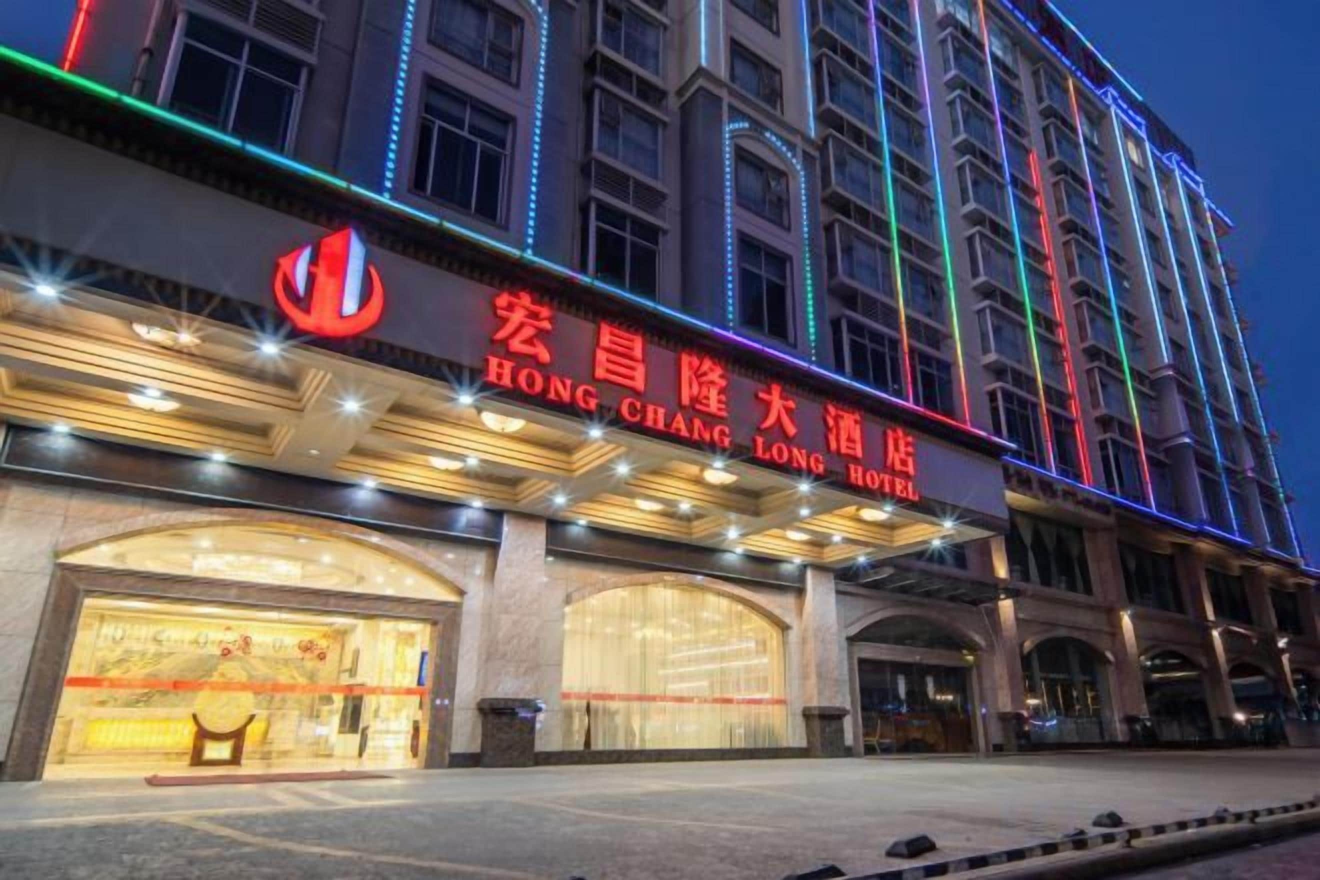 A hotel with a prominent sign, large windows, and a well-lit facade.