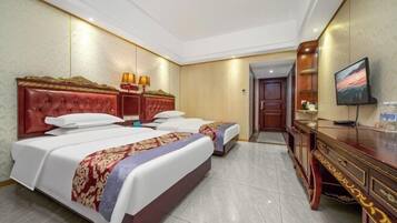Een hotelkamer met twee bedden, een houten dressoir, een televisie en een deur naar een andere kamer.