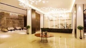 A modern lobby with a reflective floor, a round table, and a seating area with sofas. - Ramada Plaza by Wyndham Changsha South (Changsha)