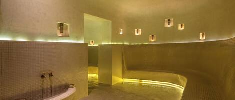 A modern bathroom with a freestanding bathtub, a wall-mounted sink, and recessed lighting.