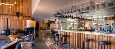 A modern bar area with wooden accents, a checkered floor, and bar stools.