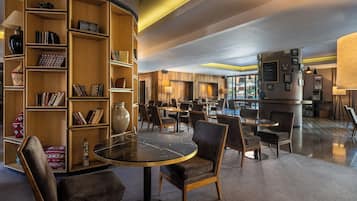 Una biblioteca moderna con estanterías, una mesa de mármol y asientos cómodos.