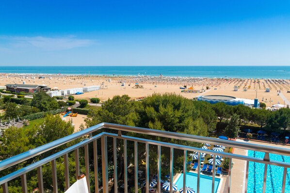 Un complexe hôtelier en bord de mer, doté d’une piscine, de parasols et offrant une vue sur l’océan.