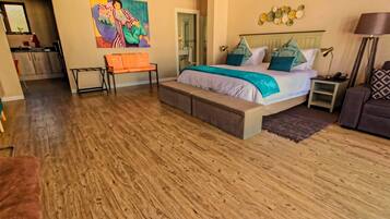 A spacious bedroom with a large bed, a bench, a desk, and a chair.