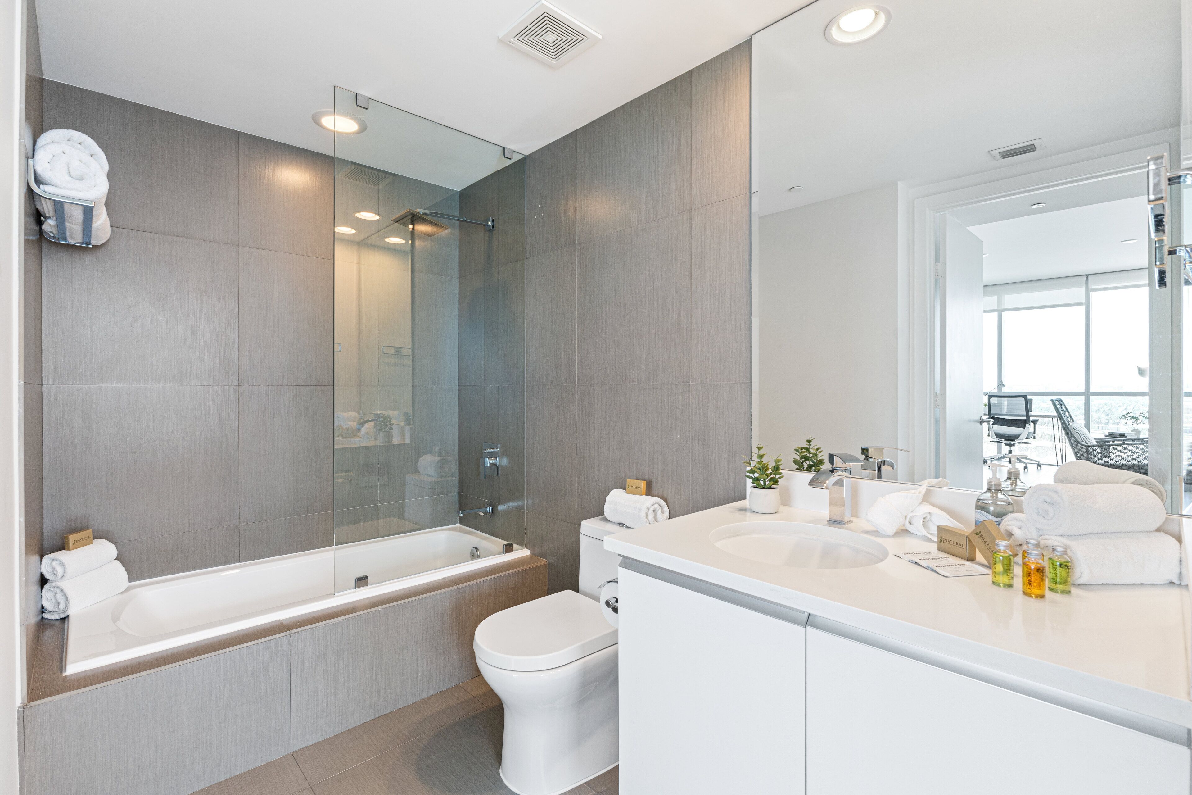 Een moderne badkamer met een bad, toilet en wastafel.
