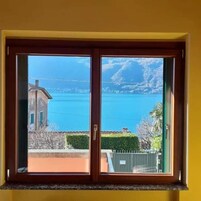 Una habitación con un ventanal grande que ofrece vista a un cuerpo de agua y montañas distantes.