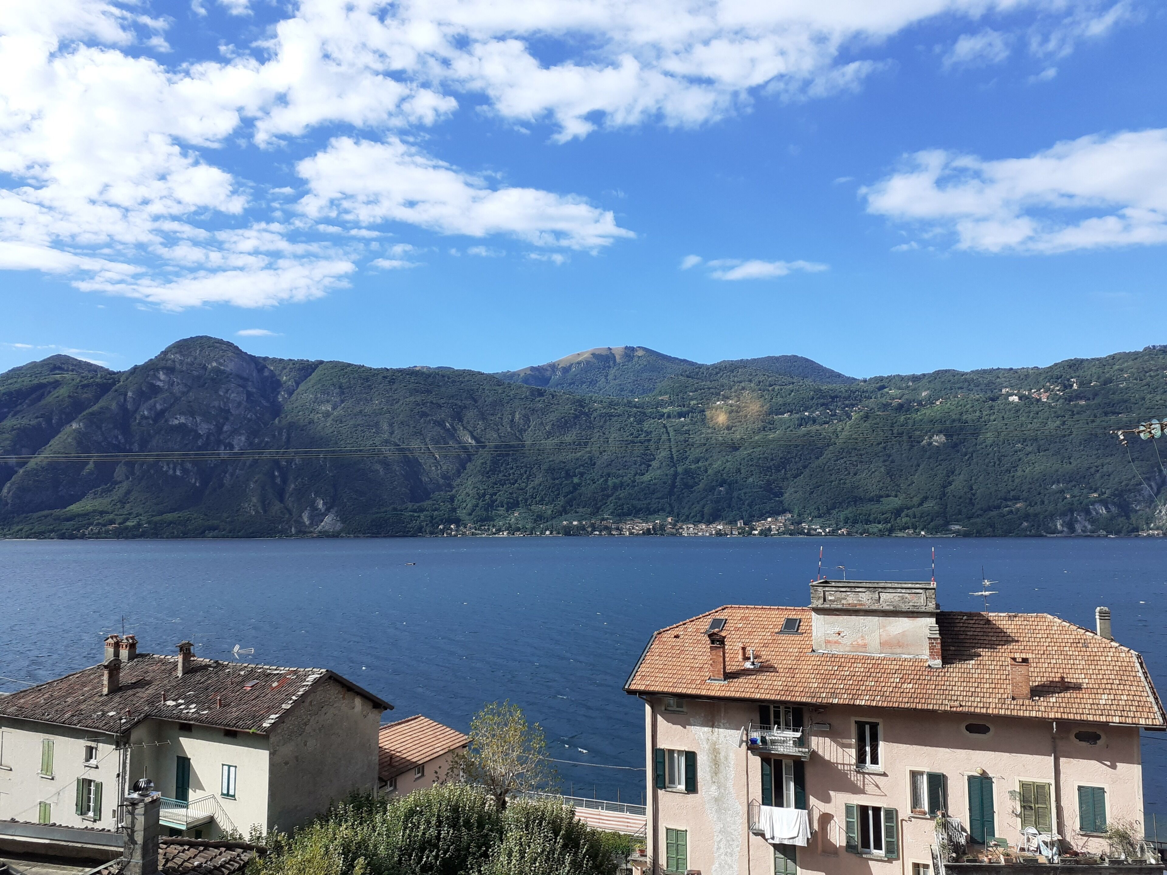 Vista sulla costa, con edifici e montagne sullo sfondo.