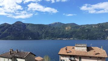 Vista sulla costa, con edifici e montagne sullo sfondo.
