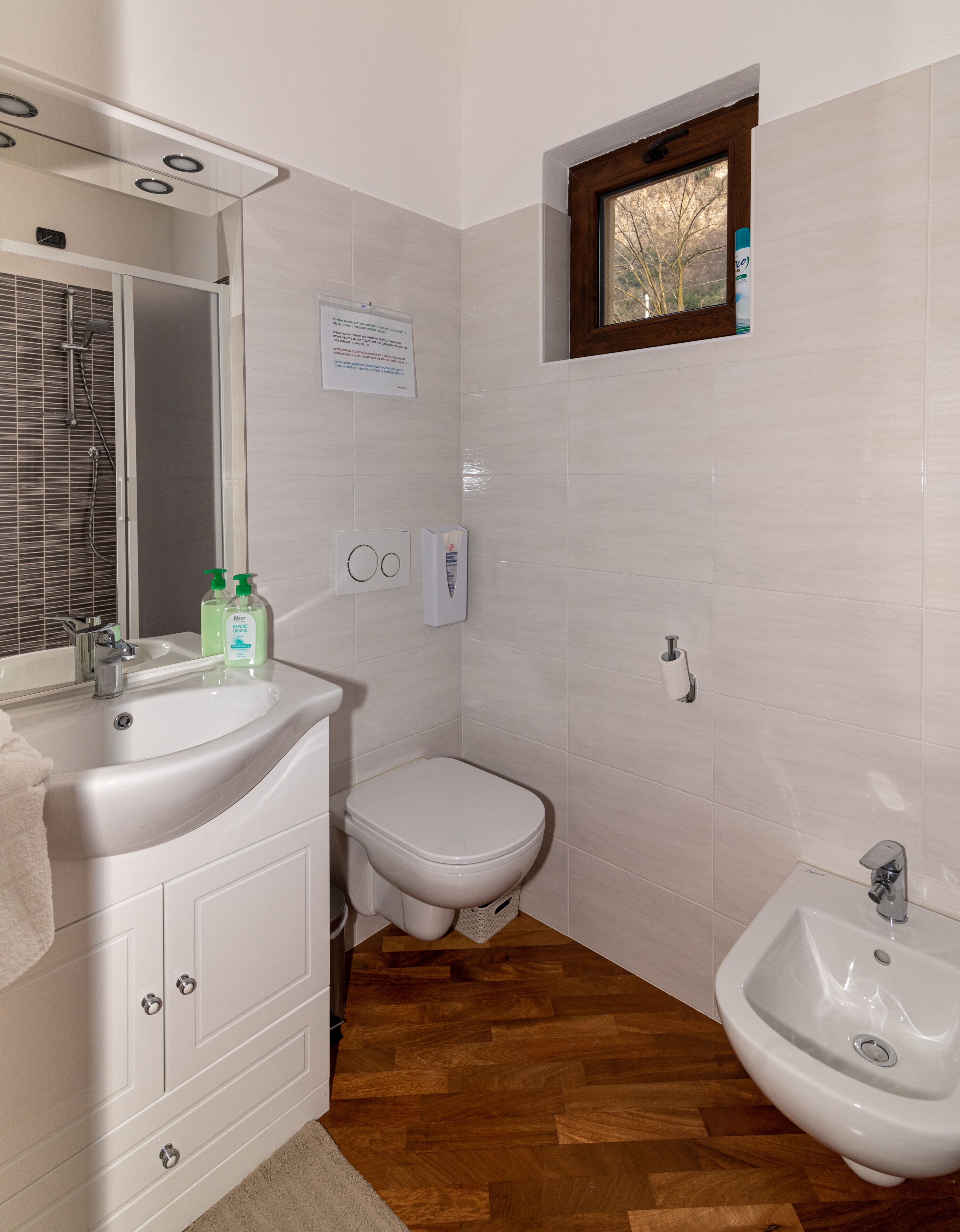 Un baño con lavamanos, inodoro, bidé y espejo.