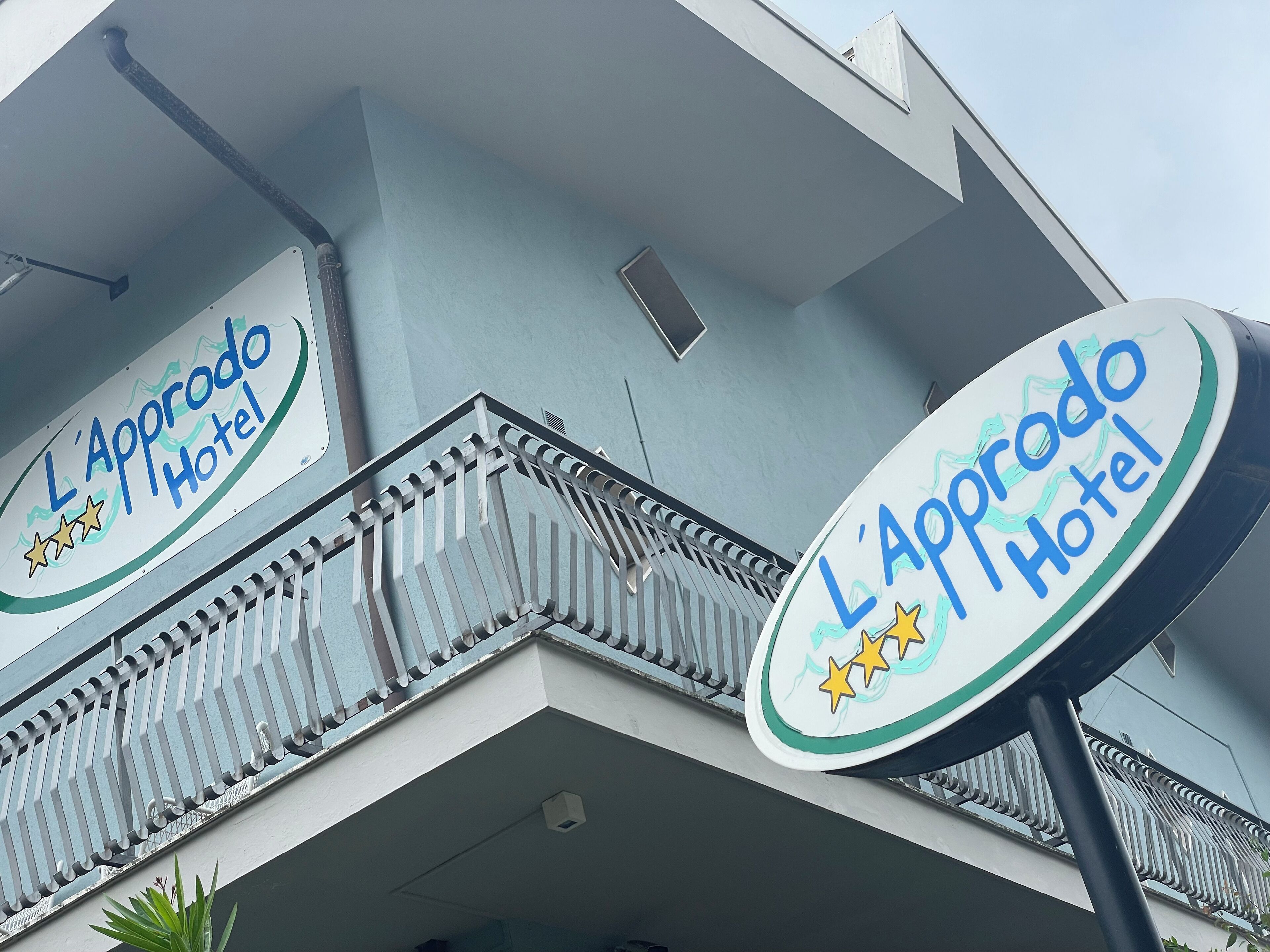 Exterior del Hotel L'Approdo, con un balcón y señalización.
