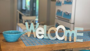 A wooden table with a blue bowl and a 'Welcome' sign. - Hotel L'Approdo (Cesenatico)