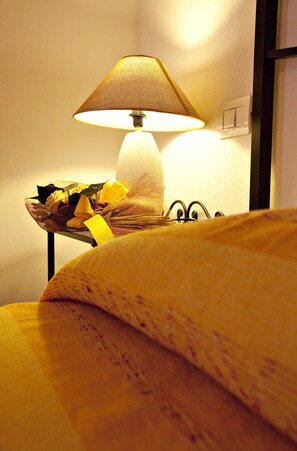 Un lampadari damunt una taula de nit amb un cistell de flors.