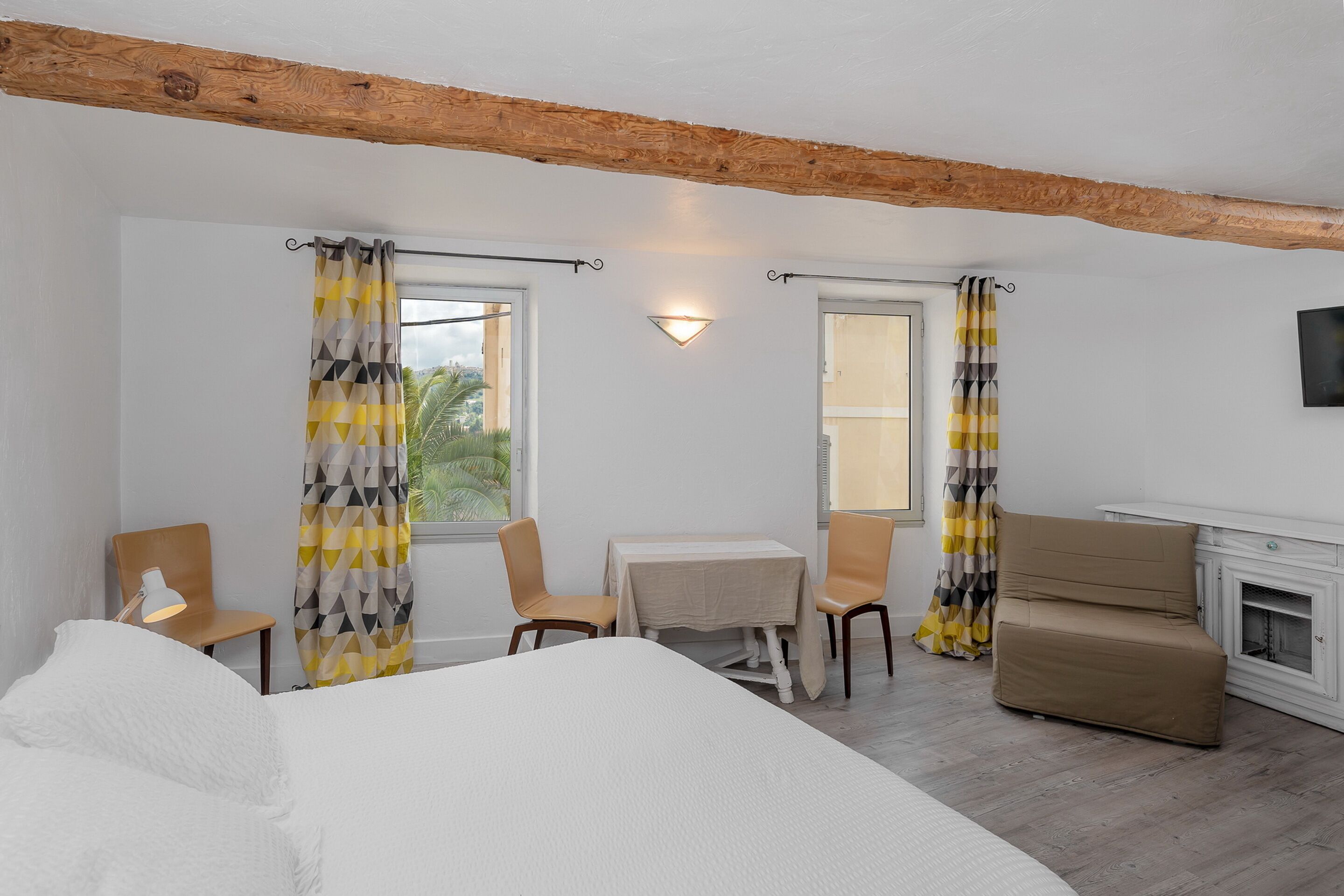 Habitació d'hotel amb un llit, una taula petita amb cadires, un sofà i una llar de foc.